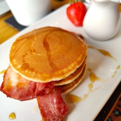 bacon and pancakes with a drizzle of maple syrup