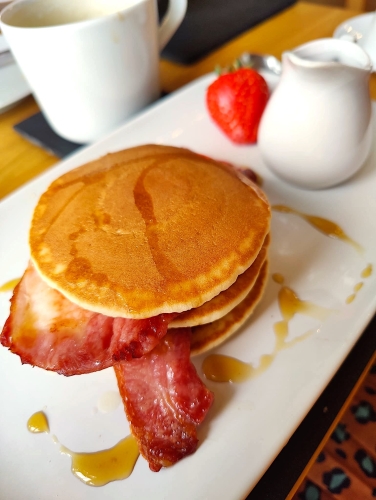 bacon and pancakes with a drizzle of maple syrup