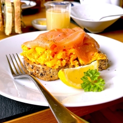 salmon and scrambled egg on toast with a slice of lemon